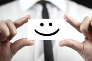 Smile on a notecard held by a businessman