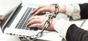 Hands locked to a keyboard with chain and handcuffs