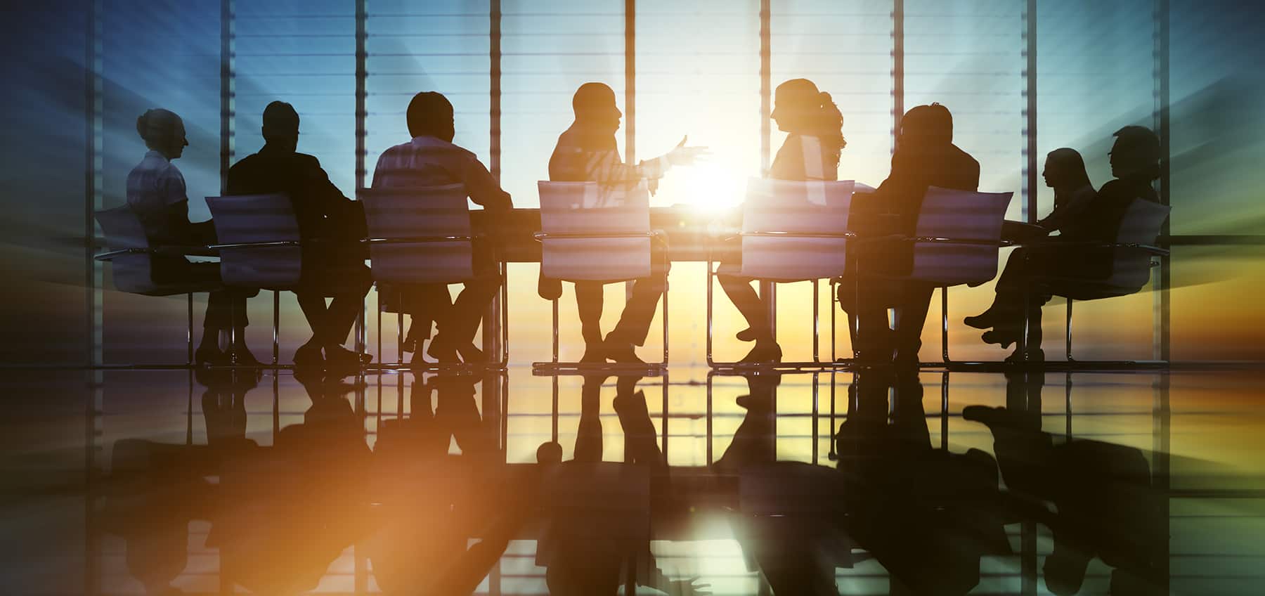 Adults sitting at a conference room table with the sun shining through leaving individuals in silhouette. Who is an employee and who is an independent contractor?