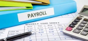Payroll binder, a weekly time sheet, and a calculator